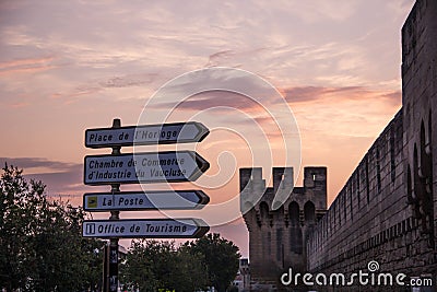 Direction signs with the background of the city walls of Avignon, France Editorial Stock Photo