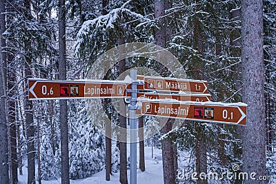 Directional sign in Repovesi National Park in winter. Showing distance to different campfire sites. Kouvola, Finland Editorial Stock Photo