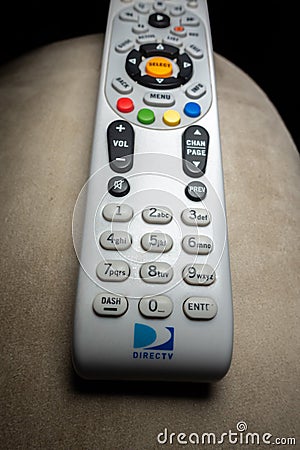 DirecTV remote shot close-up on armchair with black background. Editorial Stock Photo