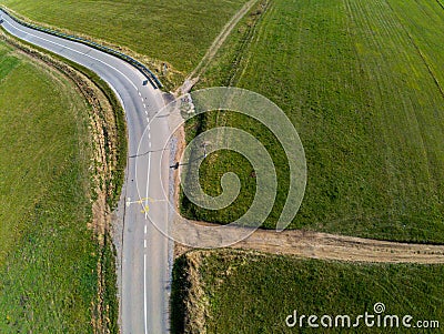 Dirt road intersecting the asphalt road drone view, simple catholic cross Stock Photo