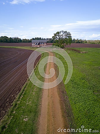 Dirt road leading to an abandoned home Stock Photo