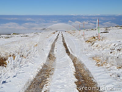 Dirt Road in a Snowy High Mountain Plateau Stock Photo