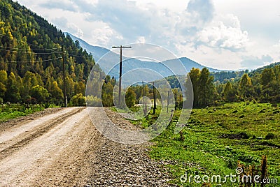 Dirt road stretches into the distance in the mountains. Stock Photo