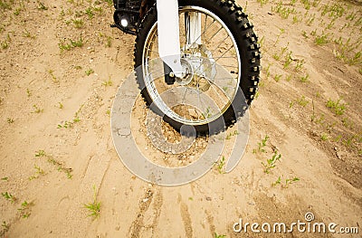 Dirtbike front wheel on muddy rural road in countryside. Stock Photo