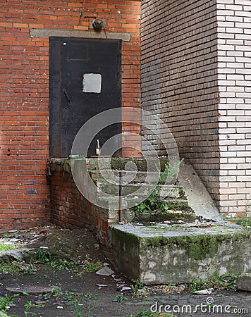 Dirty abandoned closed entrance to a brick building entrance Stock Photo