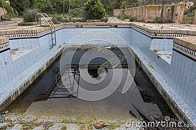 A dirty and abandoned pool with little water Stock Photo