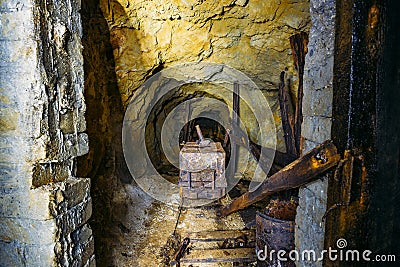 Dirty abandoned uranium mine with rusty rail and trolley Stock Photo