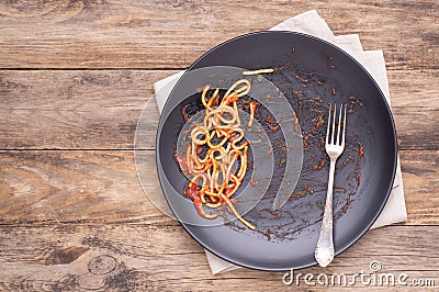 Dirty black plate with leftovers on wooden table, top view Stock Photo