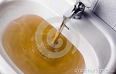 Dirty brown water running into a sink Stock Photo