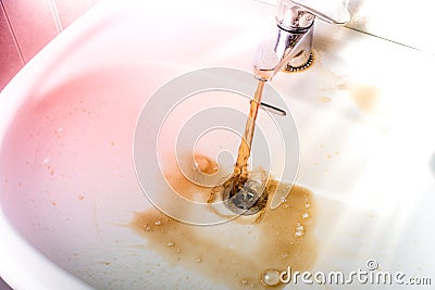 Dirty brown water running into a sink Stock Photo