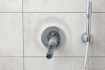 Dirty calcified shower mixer tap, faucet with limescale on it, plaque from hard water, Chrome plated shower, close up Stock Photo