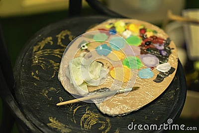 Dirty colorful artists palette on cardboard for mixing vibrant oil colors, dark wooden background. Art hobby, expression Stock Photo