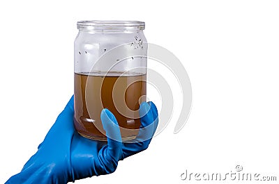 dirty contaminated infectious water in a jar in hand rubber glove isolated on white Stock Photo