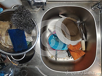 Dirty dishes in the kitchen sink clogged. Complete mess Stock Photo