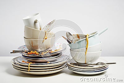 Dirty dishes pile needing washing up on white background Stock Photo