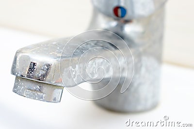 Dirty faucet with limescale, calcified water tap with lime scale on washbowl in bathroom Stock Photo