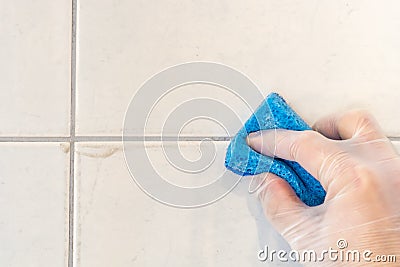 Tile joint is cleaned of dirt and mold with a sponge Stock Photo