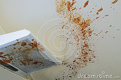 Dirty kitchen. Boiled condensed milk on kitchen hood and ceiling surface after the hot tin can exploded Stock Photo