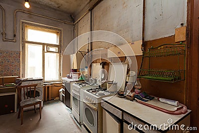 Dirty kitchen with furniture and gas stoves is in the apartment for temporary living existence refugees who were forced to mig Stock Photo