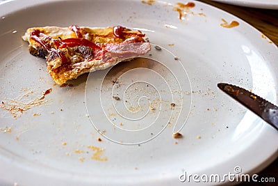 Dirty messy plates after pizza eating with unclean used utensils in the cafe. Stock Photo