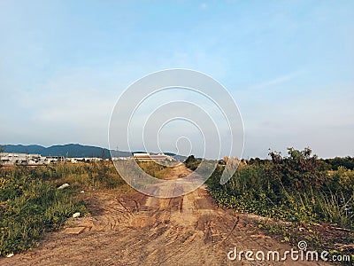 A dirty off road small road leading to a industrial area Stock Photo