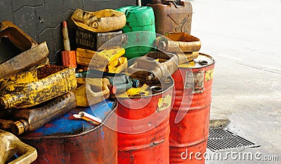 Dirty & oily plastic canisters on waste oil barrels tank Stock Photo
