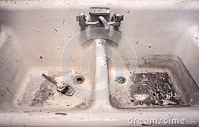Dirty old white porcelain work sink with dried paint brush sitting in messy crud Stock Photo