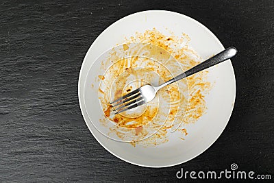 Dirty Plate on Black Stone, Empty Bowl after Dinner, Finished Lunch, Oil and Smeared Sauce Stock Photo