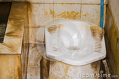 Dirty Squat Toilet used by squatting, rather than sitting. Stock Photo