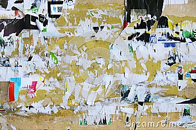 Dirty street yellow wall with old torn and peeling poster paper Stock Photo