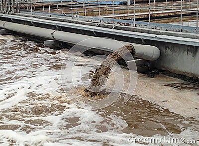 Dirty water flows from a pipe. Stock Photo