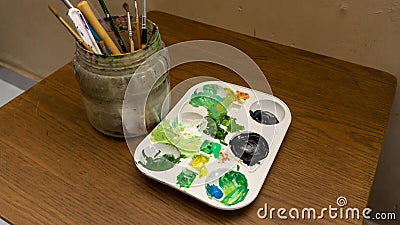 Dirty watercolor brushes set in a plastic container and color palette Stock Photo