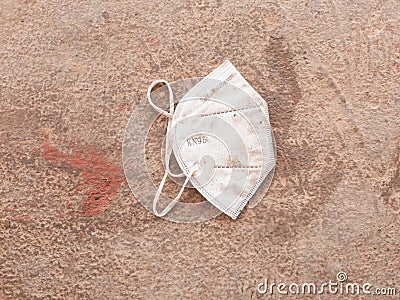 Dirty white kn95 masks that can& x27;t be used are thrown on the floor Stock Photo