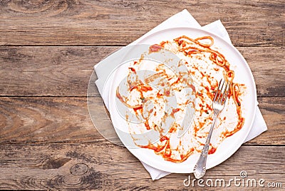 Dirty white plate with leftovers on wooden table, top view Stock Photo