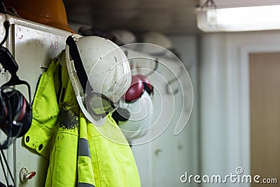 Dirty worker protective clothing hanging in the locker room. Stock Photo
