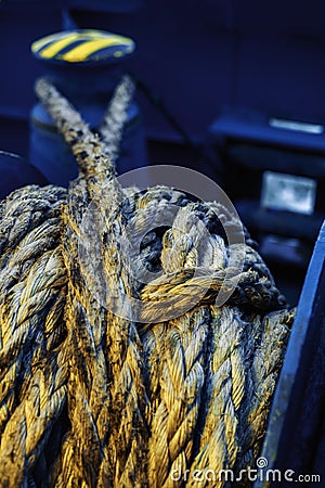 Dirtymooring line on winch. Background. Copy space. Blur. Blue and yellow Stock Photo