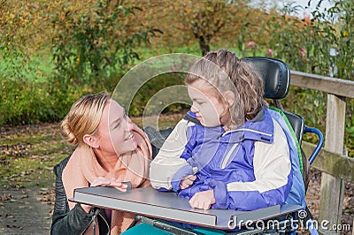 Disabled girl in a wheelchair relaxing outside Stock Photo