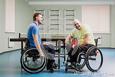 Disabled adult men laughing after playing table tennis Stock Photo