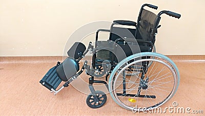 Disabled carriage. Black wheelchair in the hospital for the transportation of seriously ill people Stock Photo