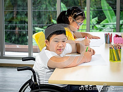 A disabled child in a wheelchair and a cute little girl with down syndrome Stock Photo