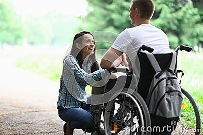 Disabled couple in love on a walk in park portrait. Wife looks at her husband in love with eyes Stock Photo