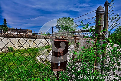 Disabled gate button at Abandoned factory building with broken windows in lake mills WI Stock Photo