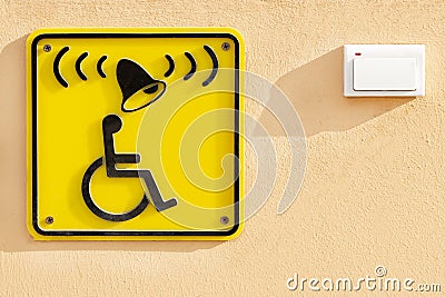 Disabled help call button. yellow plate with the image of a disabled person and a call button Stock Photo