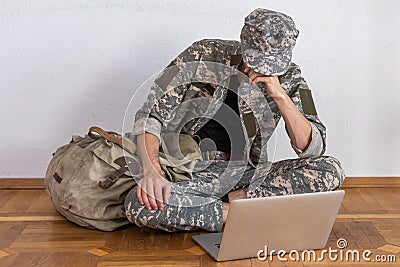 Disabled male veteran sitting and praying. He is wearing military uniform Stock Photo