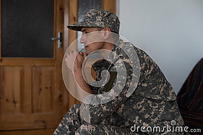 Disabled male veteran sitting and praying. He is wearing military uniform Stock Photo
