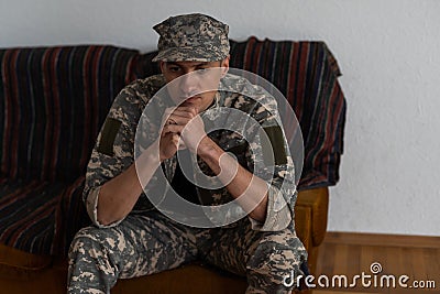 Disabled male veteran sitting and praying. He is wearing military uniform Stock Photo