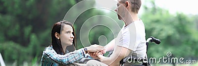 Disabled male veteran is sitting in wheelchair woman is sitting nearby Stock Photo