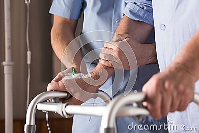 Disabled person walking with assistance Stock Photo