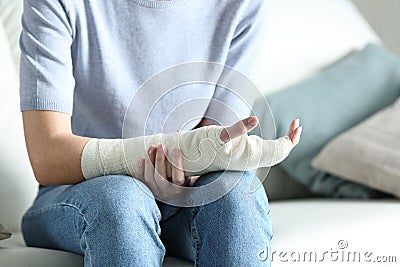 Disabled woman grabbing her painful bandaged arm Stock Photo