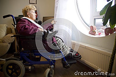 Disabled woman looks out the window Editorial Stock Photo